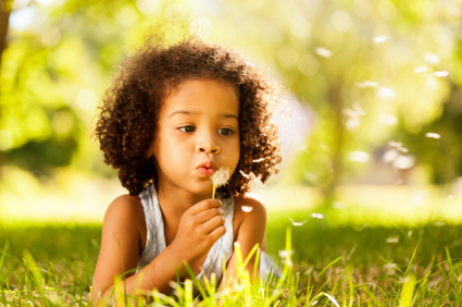 Girl blowing on dandelion seeds - Pediatric Dentist in Keller, Fort Worth and Southlake, TX - Bridget McAnthony, DDS